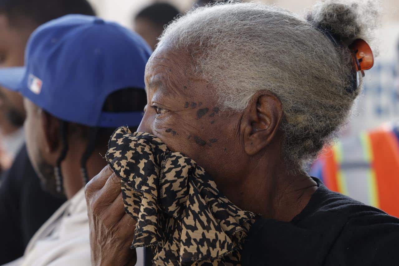 Una residente del sector Magdalena se cubre la nariz con un paño ante la intensidad del humo que se expandió por la comunidad tras el incendio en una empresa de Haina.