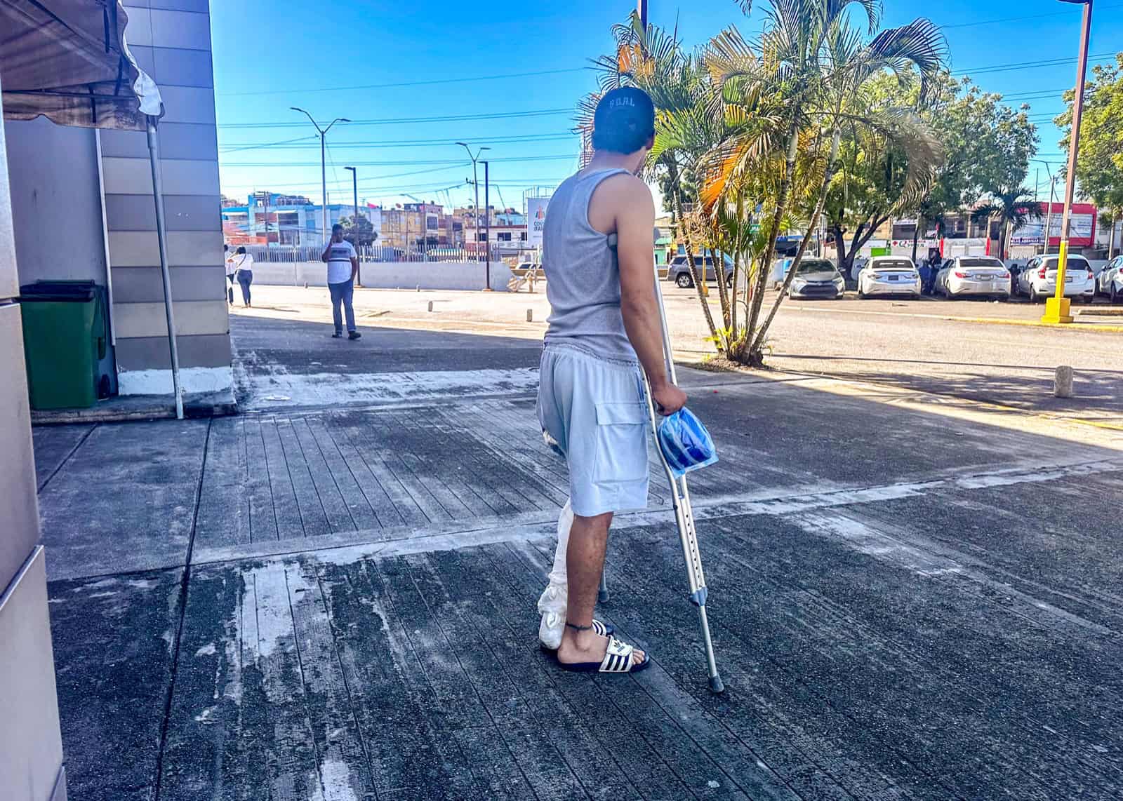 Alexander Santiago, de 38 años, se desplaza con dificultad apoyado en muletas como consecuencia de un accidente de tránsito.