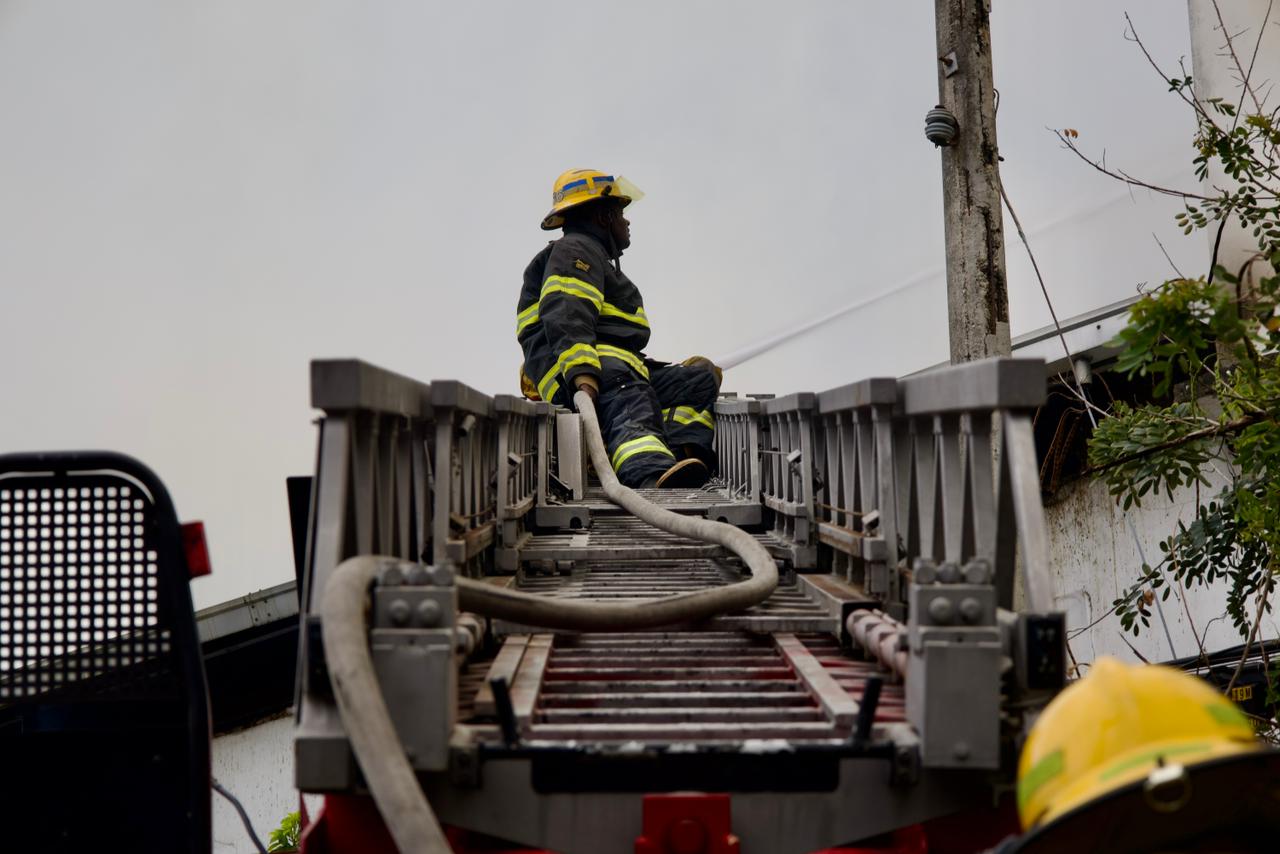 Bomberos continúan labores para sofocar las llamas en el almacén afectado.