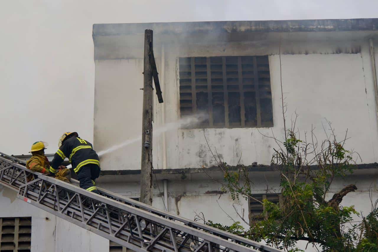 Bomberos combaten las llamas en el almacén de carga afectado por el incendio.