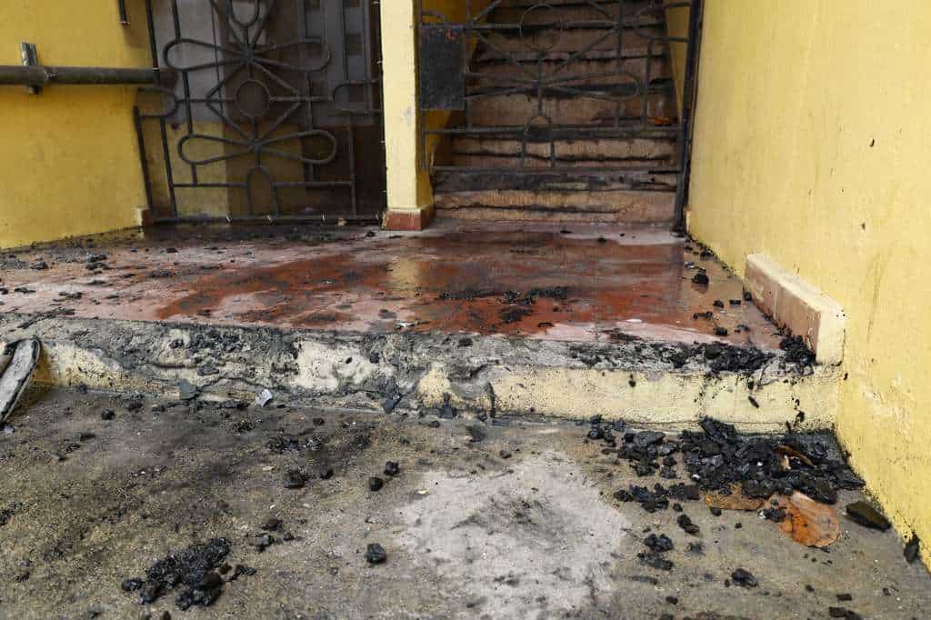 Restos frente a la entrada del edificio donde ocurrió el fatal incendio, mientras las autoridades continúan con las investigaciones sobre la muerte de Aleny Pineda.