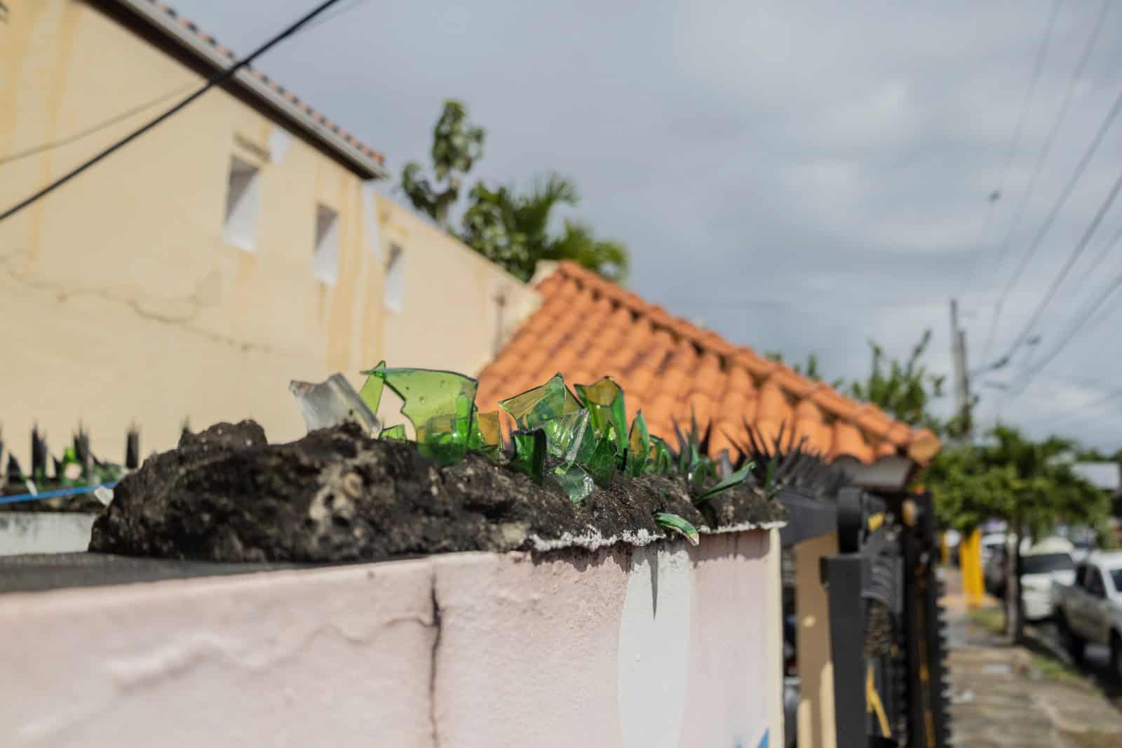 Botellas de vidrio incrustadas en la parte superior de una pared, utilizadas como medida para dificultar el acceso de intrusos.