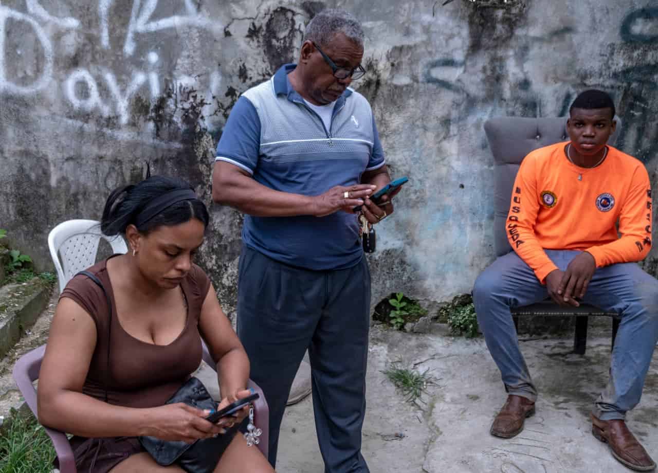 Hermana de José Manuel de León, Rosmery de León, su padre y el voluntario de la Defensa Civil, Luis Enrique Corporán.